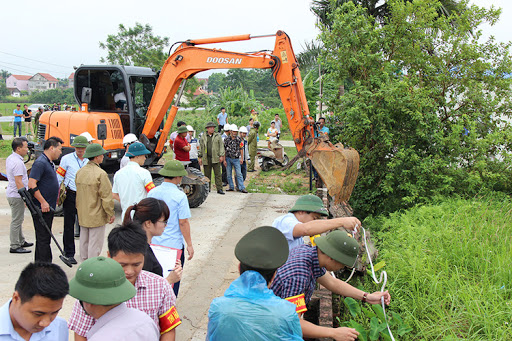 một nh&oacute;m người đang tiến h&agrave;nh đo đạc v&agrave; xem x&eacute;t thửa đất