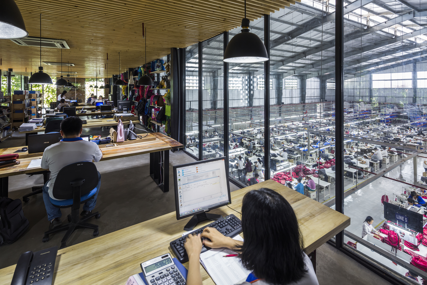 h&igrave;nh ảnh kh&ocirc;ng gian l&agrave;m việc cho khối văn ph&ograve;ng h&agrave;nh ch&iacute;nh với c&aacute;c b&agrave;n đặt m&aacute;y t&iacute;nh, đ&egrave;n thả m&agrave;u đen, trần ốp gỗ