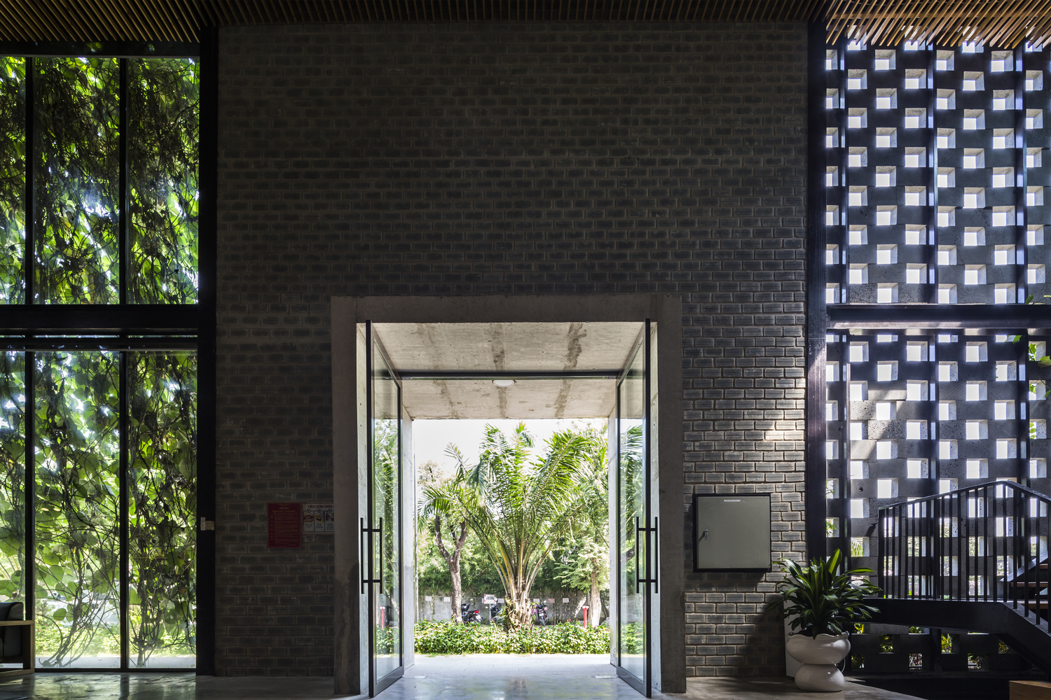 h&igrave;nh ảnh cận cảnh lối v&agrave;o nh&agrave; xưởng nh&igrave;n từ trong ra với tường gạch trần m&agrave;u x&aacute;m