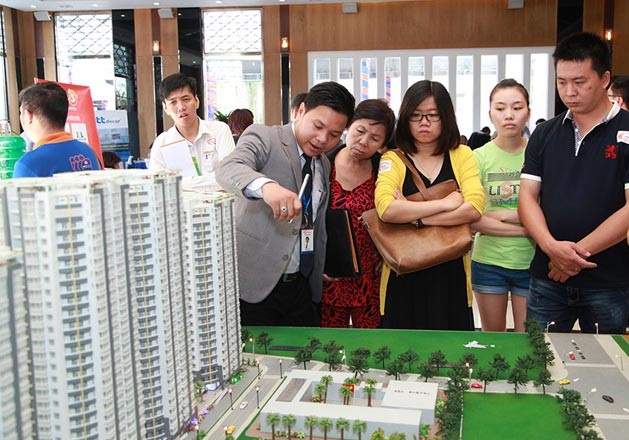 m&ocirc;i giới đang giới thiệu về khu chung cư th&ocirc;ng qua m&ocirc; h&igrave;nh cho kh&aacute;ch h&agrave;ng