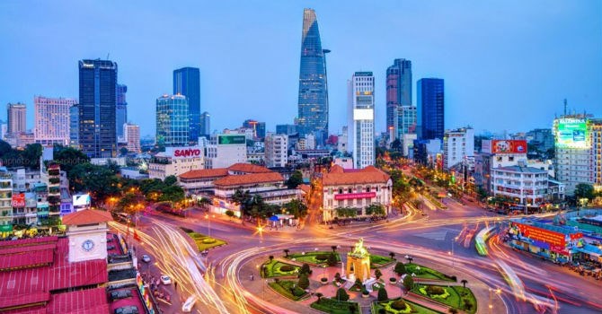 hình ảnh một góc TP.HCM khi lên đèn với các tòa nhà cao tầng xen kẽ thấp tầng, cây xanh