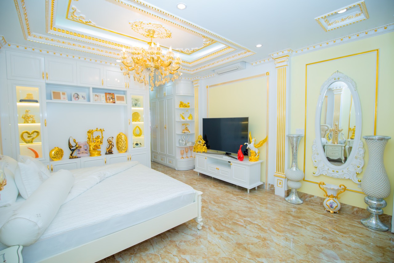 hình ảnh phòng ngủ màu vàng trắng chủ đạo với màn hình tivi nhấn nhá