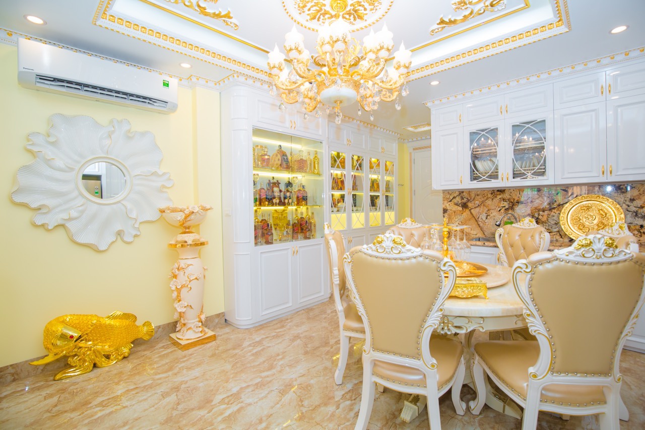 toàn cảnh phòng ăn phong cách tân cổ điển sang trọng vói gương mặt trời, bàn ăn tròn, đèn chùm, tủ rượu cửa kính trong suốt