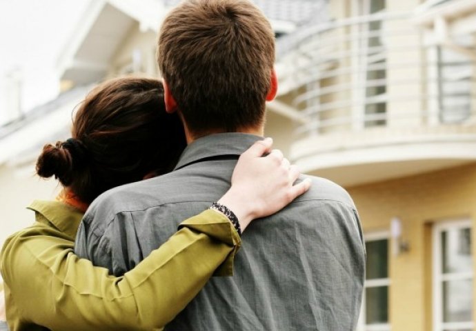 hai vợ chồng đang cùng nhìn về phía ngôi nhà