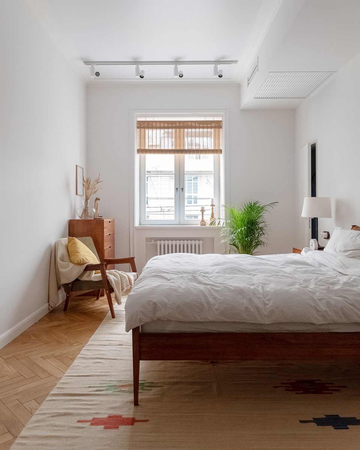 Ph&iacute;a cuối ch&acirc;n giường l&agrave; ghế ngồi thư gi&atilde;n, đọc s&aacute;ch thoải m&aacute;i. Chậu cảnh xanh tươi bổ sung sắc m&agrave;u thi&ecirc;n nhi&ecirc;n cho ph&ograve;ng ngủ.