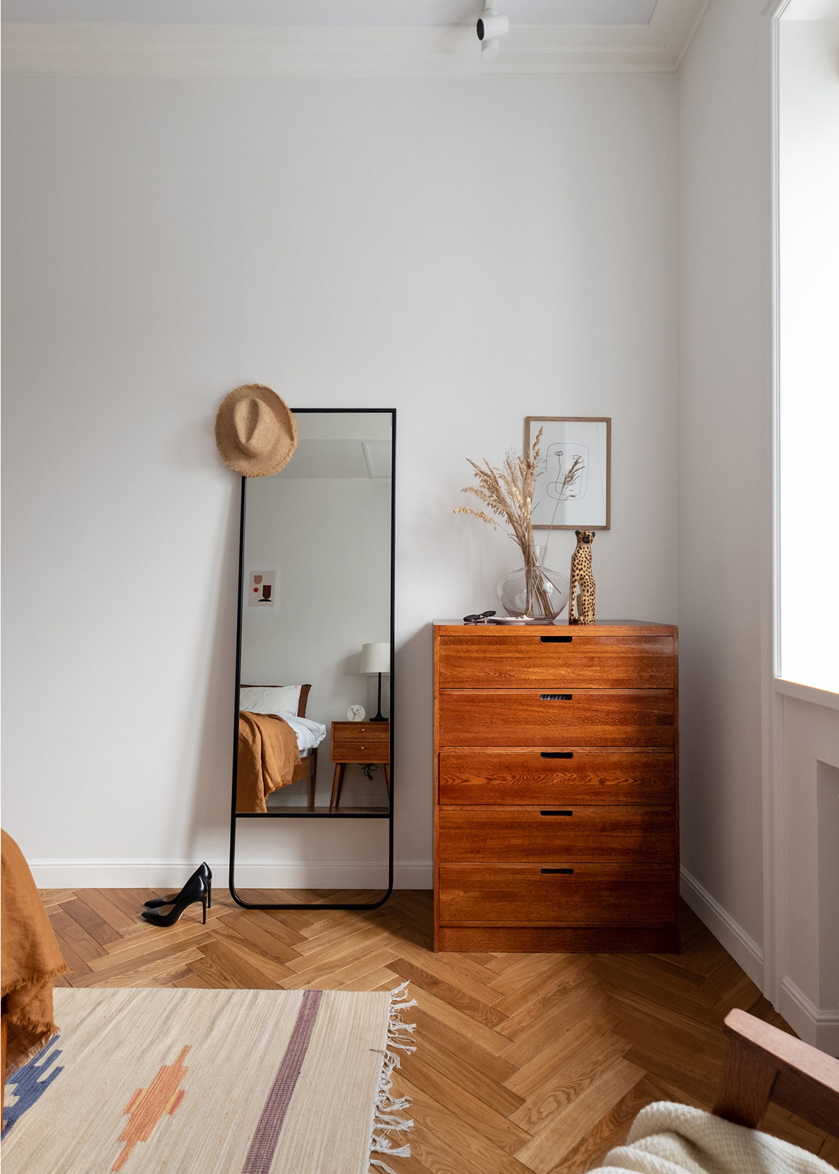 Một b&igrave;nh hoa kh&ocirc; bằng thủy tinh v&agrave; tượng động vật tạo n&ecirc;n sự đồng điệu với khung tranh nghệ thuật treo tường.