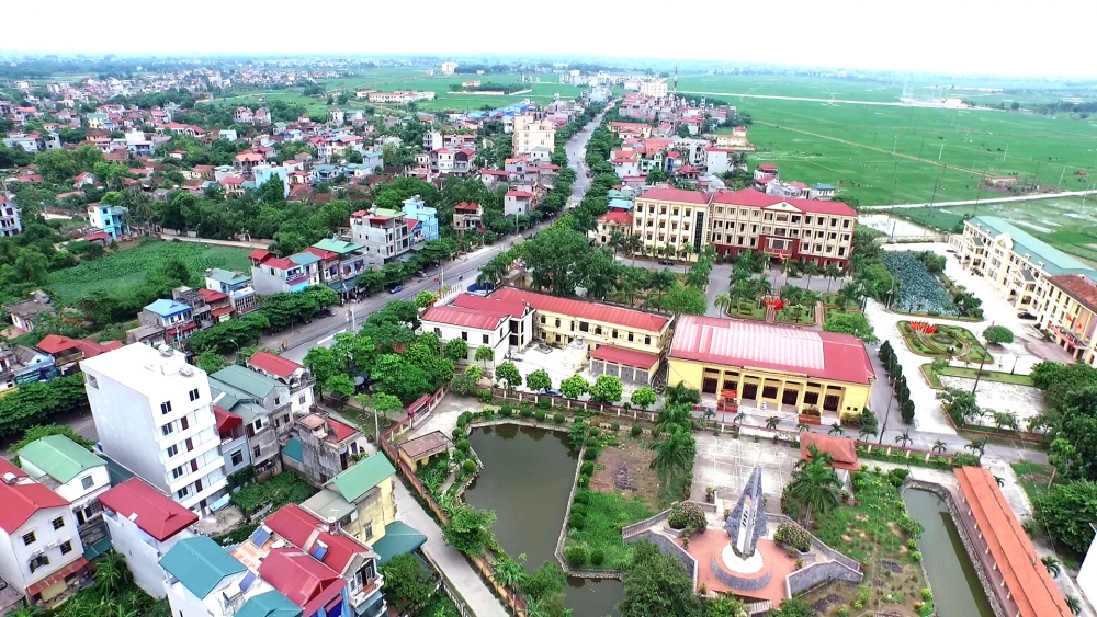 nhiều công trình, nhà ở xen lẫn cây cối, hồ nước nhìn từ trên cao