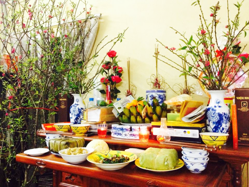 hình ảnh bàn thờ gia tiên ngày Tết với cành đào nở hoa, mâm ngũ quả, bánh chưng