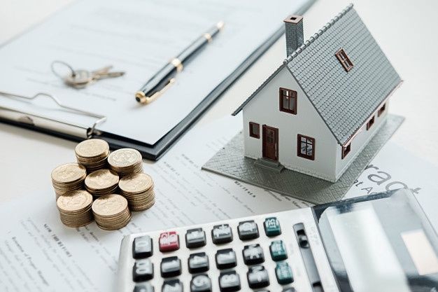 hình ảnh mô hình ngôi nhà, cọc tiền xu, giấy bản vẽ, máy tính cầm tay