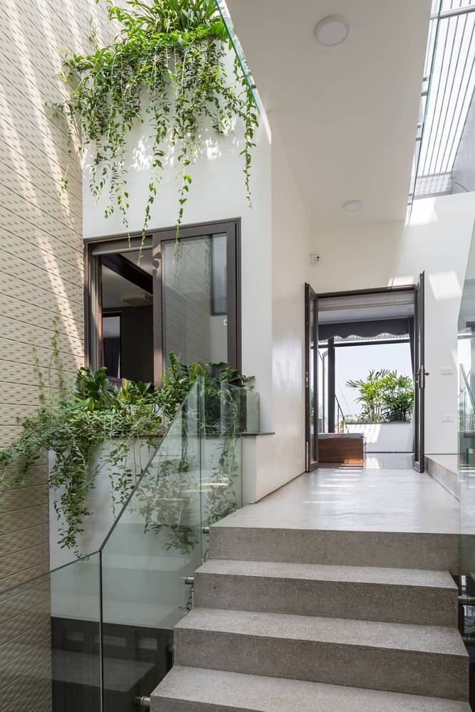 cầu thang nhà ống với bậc bê tông, lan can kính cường lực