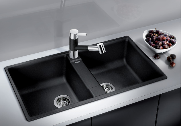 hình ảnh cận cảnh bồn rửa bát đôi màu đen, cạnh đó là đĩa đựng hoa quả