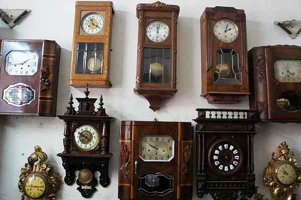 hình ảnh cận cảnh hàng loạt đồng hồ treo tường hộp gỗ, quả lắc