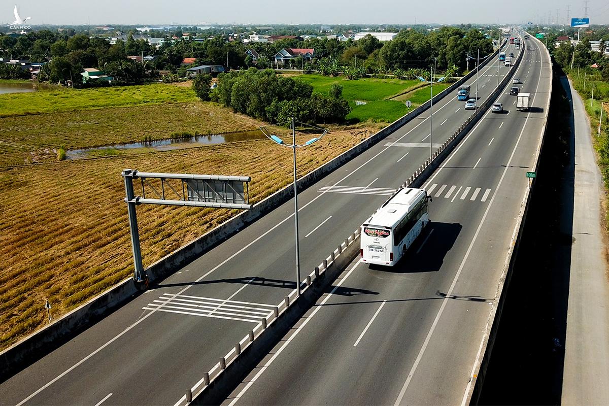 tuyến cao tốc c&oacute; xe đang chạy, nhiều c&acirc;y xanh hai b&ecirc;n đường