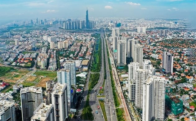 hình ảnh một góc TP.HCM nhìn từ trên cao với nhiều tòa nhà cao tầng xen kẽ khu dân cư thấp tầng, cây xanh, sông nước