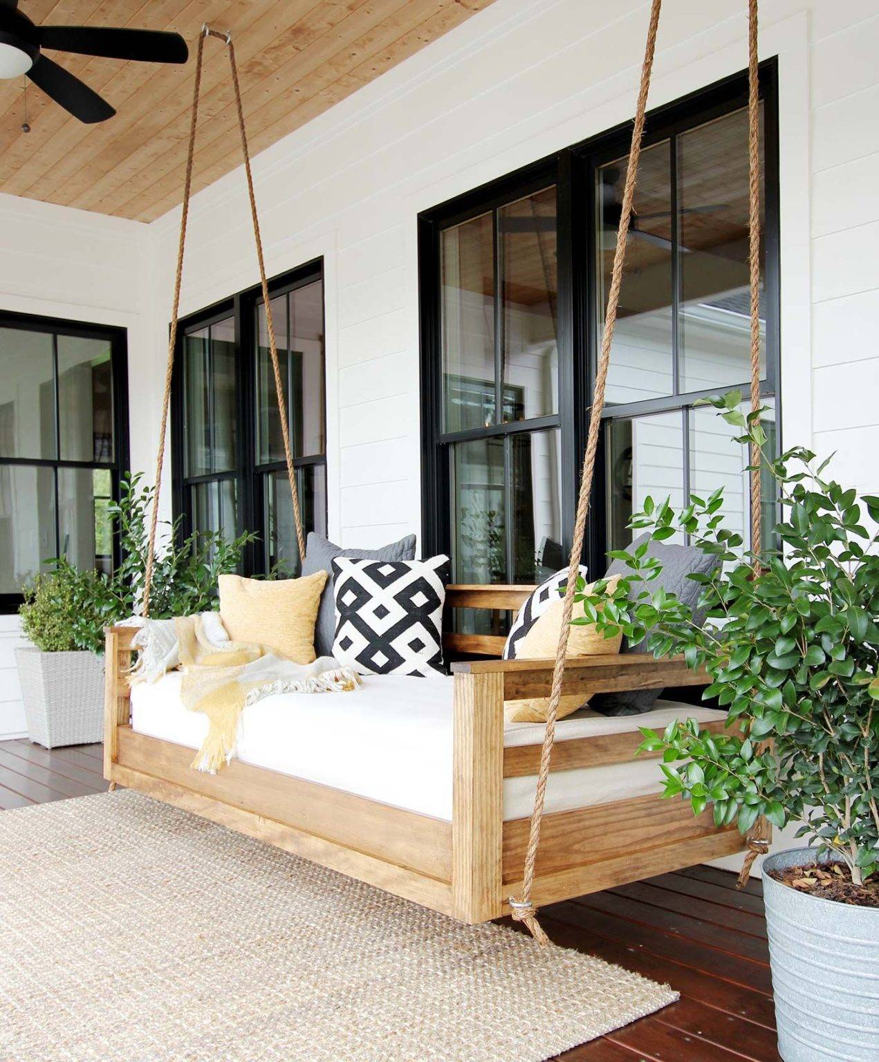h&igrave;nh ảnh cận cảnh ghế x&iacute;ch đu bằng gỗ, l&oacute;t nệm m&agrave;u trắng, treo ở hi&ecirc;n nh&agrave;