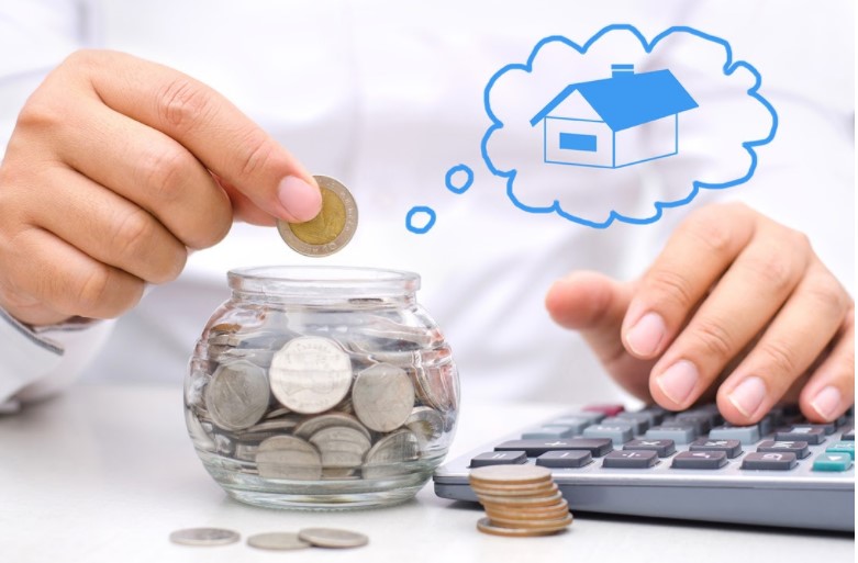 hình ảnh người đàn ông cầm đồng xu bỏ vào hộp thủy tinh minh họa cho việc mua nhà trả góp