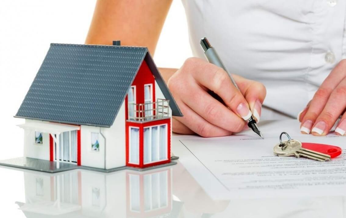 h&igrave;nh ảnh cận cảnh m&ocirc; h&igrave;nh ng&ocirc;i nh&agrave;, b&agrave;n tay k&yacute; hợp đồng minh họa cho thủ tục sang t&ecirc;n sổ hồng chung cư