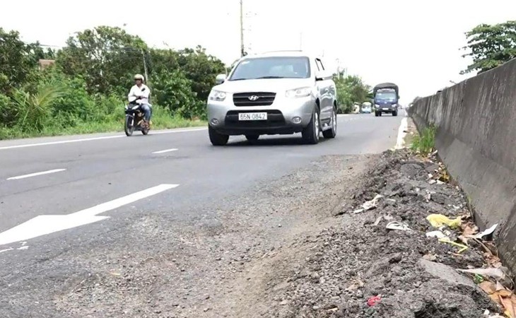 &ocirc; t&ocirc; v&agrave; xe m&aacute;y đang đi qua đường, c&oacute; c&acirc;y xanh b&ecirc;n đường