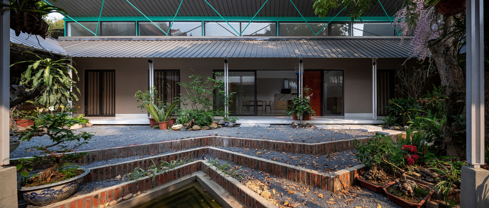 M&aacute;i nh&agrave; h&igrave;nh chữ V với điểm thấp nhất ở giữa gi&uacute;p ph&acirc;n chia ng&ocirc;i nh&agrave; th&agrave;nh kh&ocirc;ng gian ch&iacute;nh để ở v&agrave; kh&ocirc;ng gian phụ.