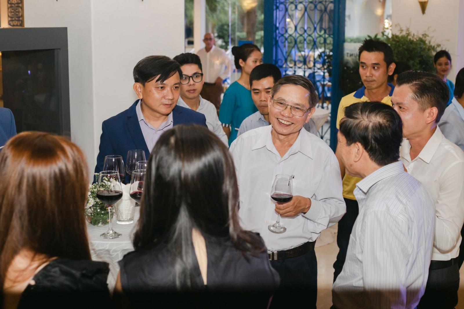 nhiều người đứng tr&ograve; chuyện trong bữa tiệc