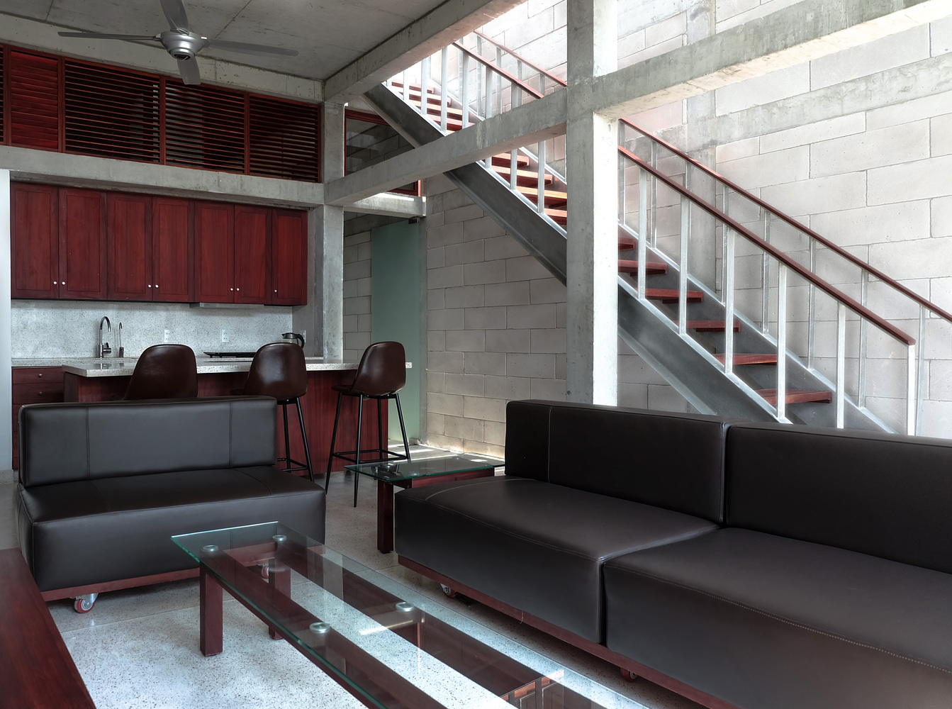 phòng khách nhà ống Đà Nẵng với bộ sofa da màu đen, tủ bếp bằng gỗ