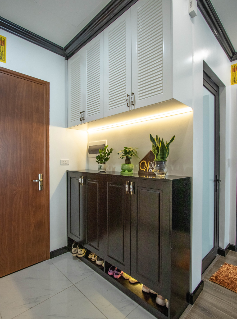 Lối vào căn hộ gọn xinh, ngăn nắp hệ tủ lưu trữ tông màu trắng - nâu sẫm vừa tạo cảm giác thoáng rộng, vừa giúp tăng chiều sâu cho không gian.