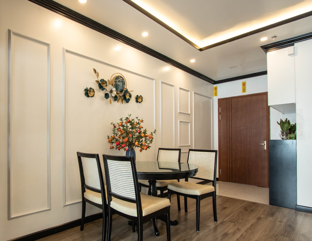 Không gian ăn uống thoáng đãng với bàn tròn quây quần ấm cúng. Những đường gờ chỉ nhẹ nhàng sinh động trên nền tường trắng.