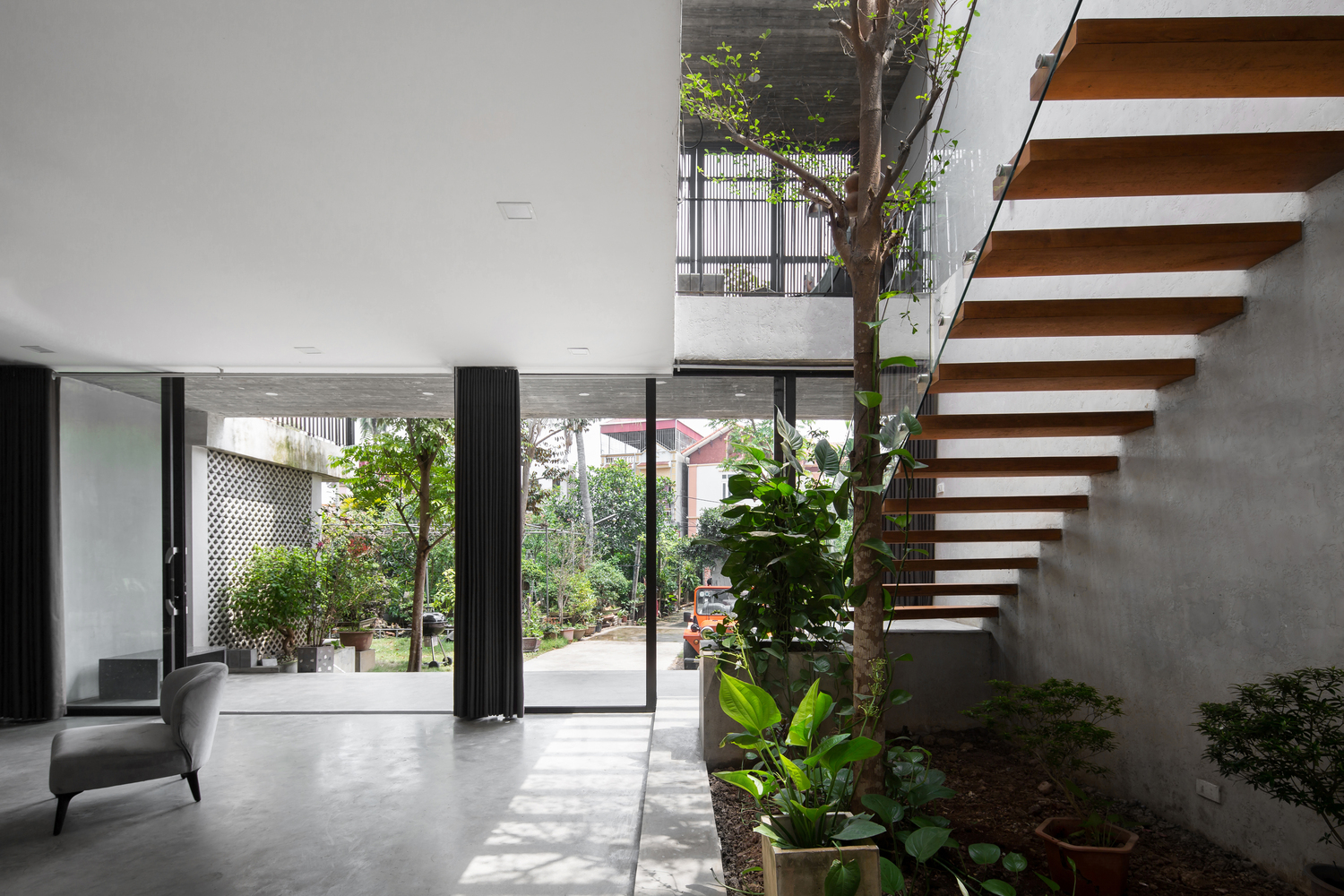 Hệ cửa kính cao rộng, trong suốt mang đến tầm nhìn rộng mở, thoáng đẹp ra khu vườn trước nhà, đồng thời cho phép ánh sáng tự nhiên lan tỏa vào mọi ngóc ngách.