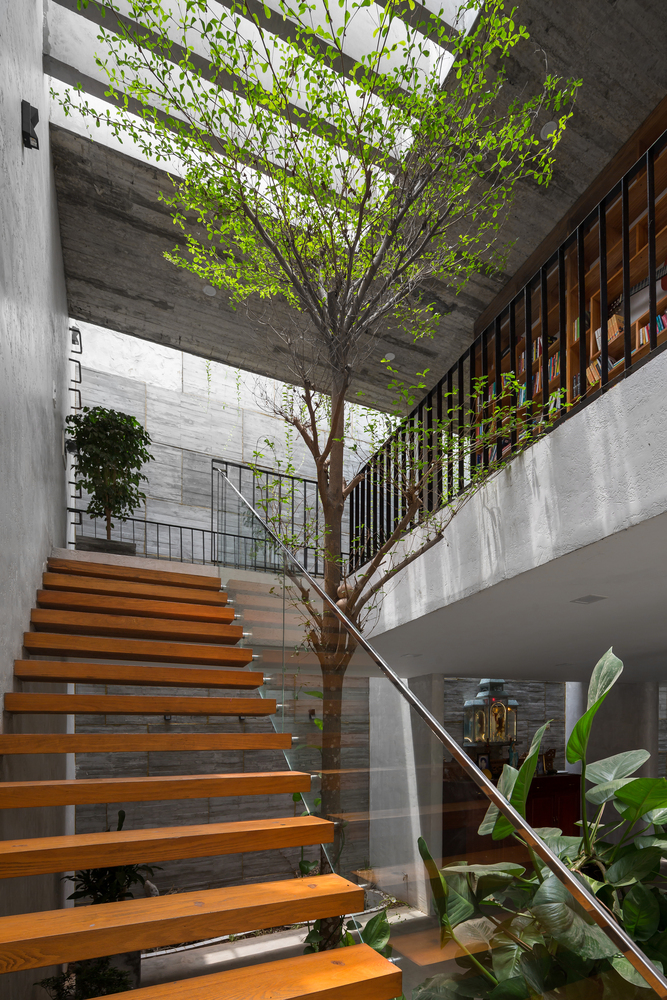 Bậc thang bằng gỗ kiểu hở kết hợp h&agrave;i h&ograve;a c&ugrave;ng lan can k&iacute;nh cường lực trong suốt tạo độ tho&aacute;ng cho kh&ocirc;ng gian, đồng thời cho ph&eacute;p &aacute;nh s&aacute;ng xuy&ecirc;n qua dễ d&agrave;ng.