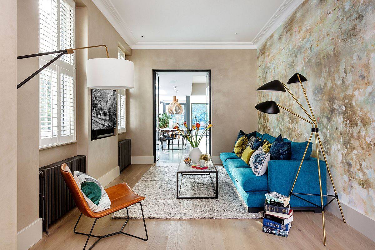 Nội thất ph&ograve;ng kh&aacute;ch được thiết kế kh&eacute;o l&eacute;o với bộ ghế sofa m&agrave;u xanh dương, ghế tựa m&agrave;u da b&ograve; nổi bật tr&ecirc;n ph&ocirc;ng nền m&agrave;u be. C&ugrave;ng với đ&oacute; l&agrave; bức tường decor cực lạ mắt.