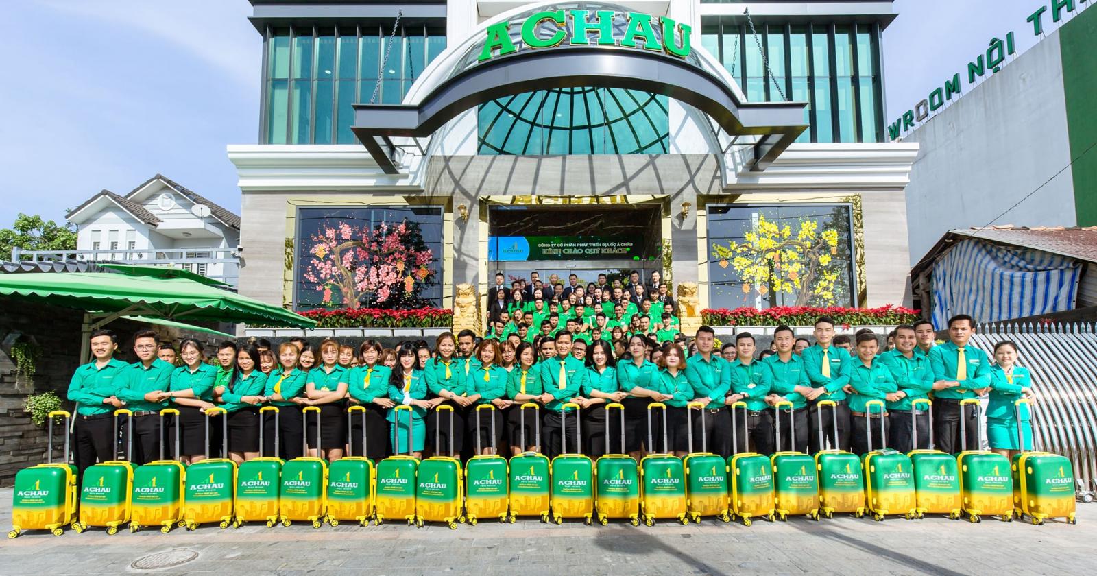 nhiều người mặc &aacute;o xanh đứng chụp ảnh trước to&agrave; nh&agrave;