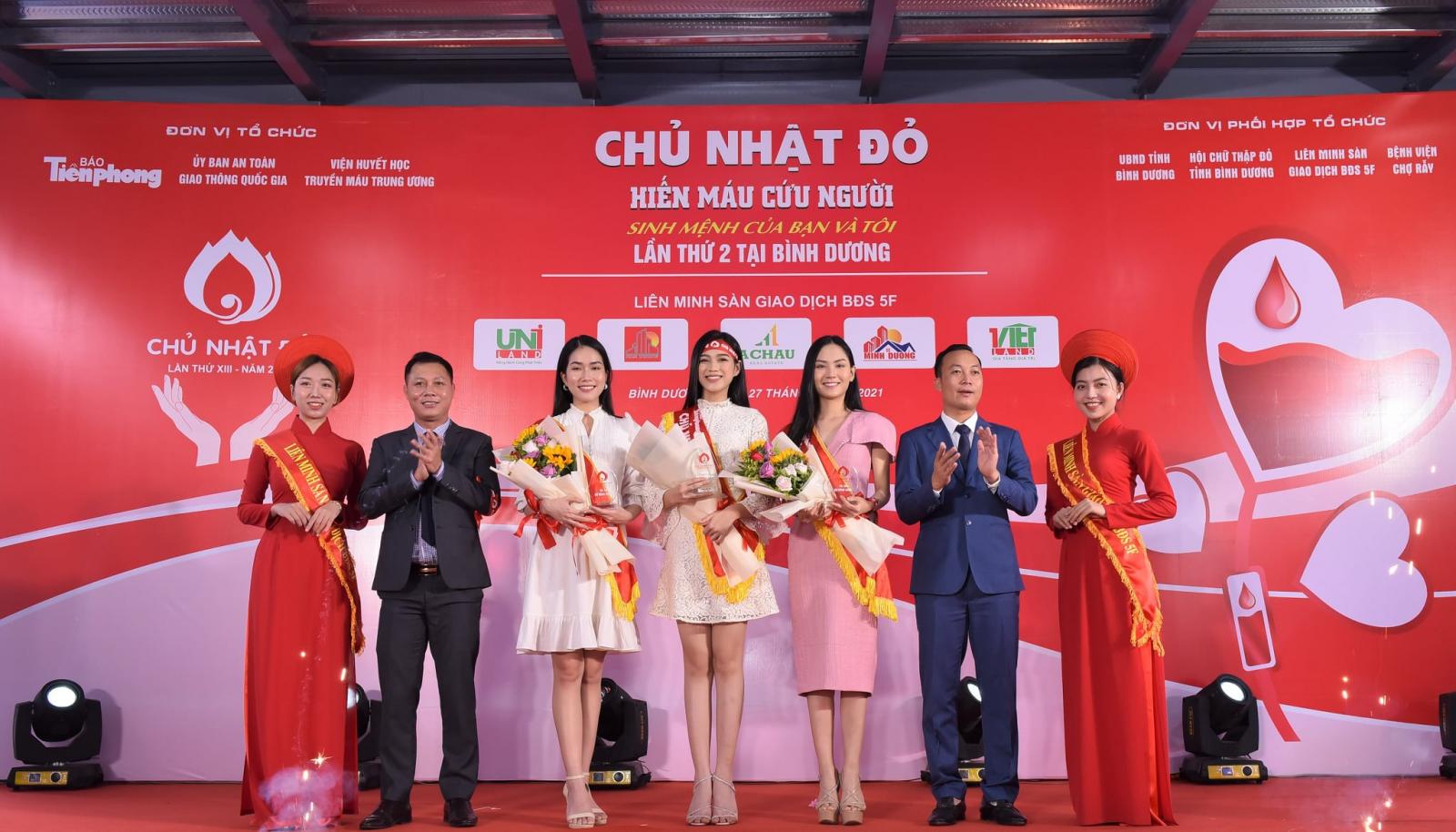 nhiều người đang đứng tr&ecirc;n s&acirc;n khấu m&agrave;u đỏ