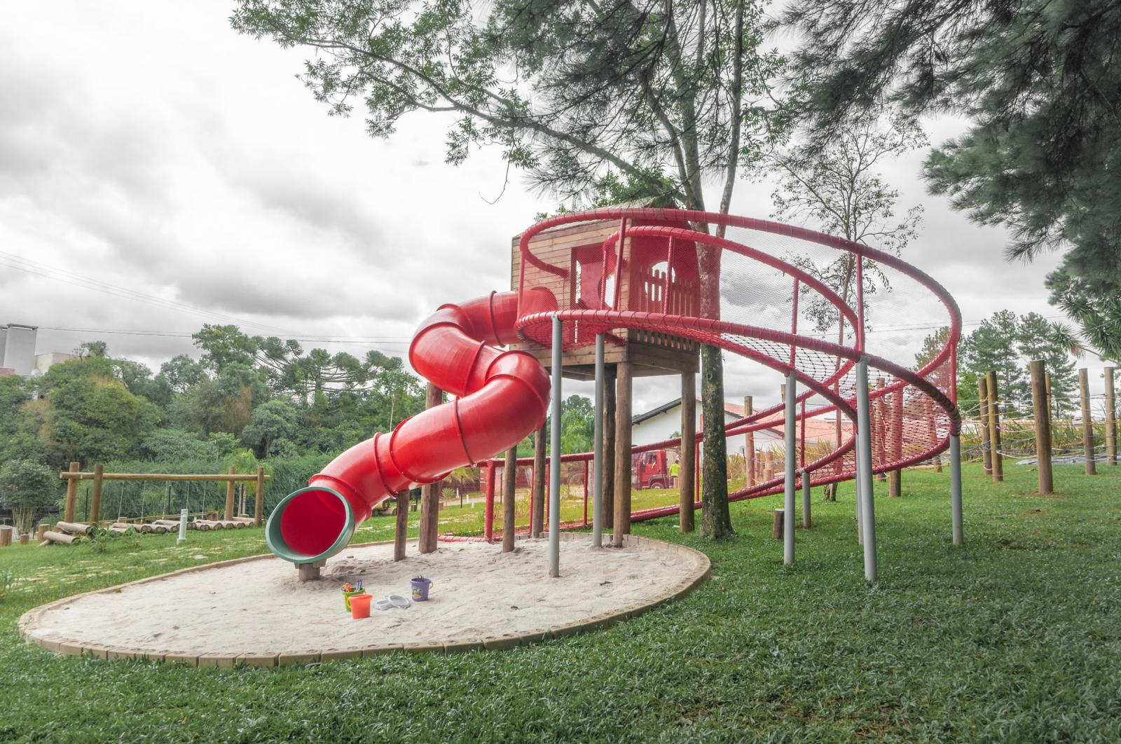 Cầu trượt màu đỏ Một đường trượt màu đỏ tươi kết thúc trong hố cát mềm mại.