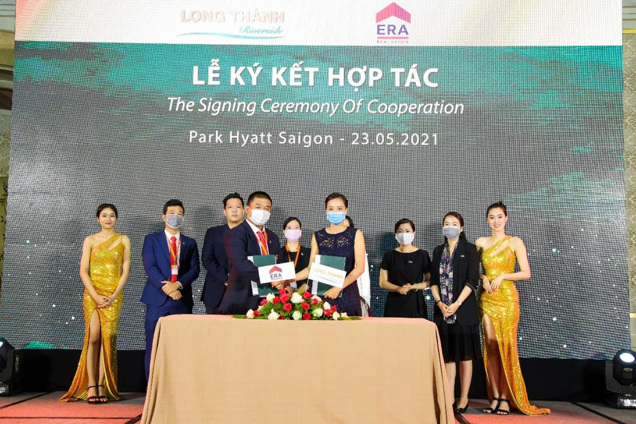 nhiều người đang đứng trên sân khấu lễ ký kết