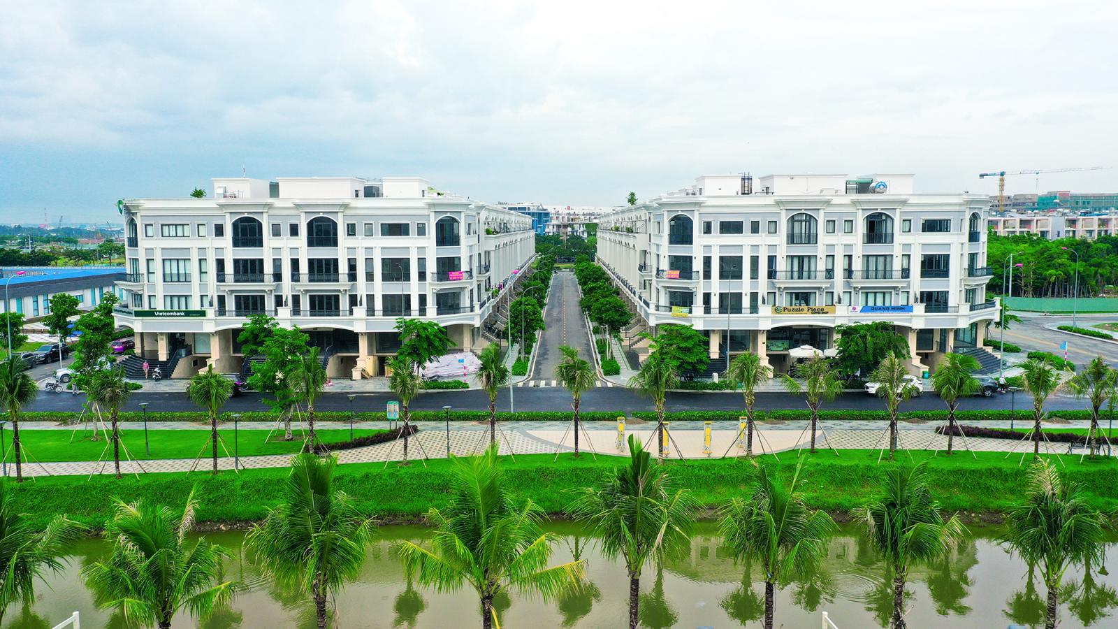 hai d&atilde;y nh&agrave; m&agrave;u trắng, ph&iacute;a trước l&agrave; đường v&agrave; c&acirc;y xanh