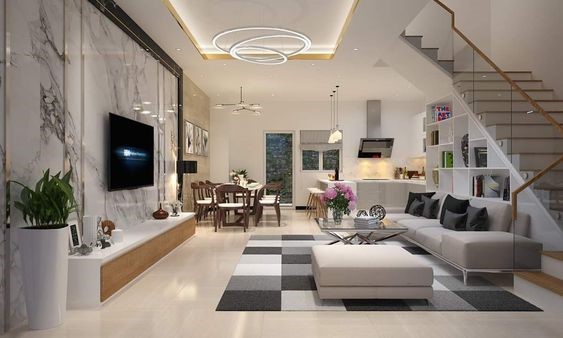 Ph&ograve;ng kh&aacute;ch biệt thự được thiết kế theo lối tối giản, hiện đại. V&igrave; kh&ocirc;ng sử dụng tường ngăn giữa khu vực tiếp kh&aacute;ch v&agrave; bếp - ăn n&ecirc;n kh&ocirc;ng gian nh&agrave; c&oacute; cảm gi&aacute;c tho&aacute;ng đ&atilde;ng hơn, rộng r&atilde;i hơn so với diện t&iacute;ch thực tế.
