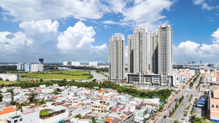 hình ảnh một góc thành phố nhìn từ trên cao với các tòa nhà cao tầng xen kẽ khu dân cư thấp tầng, cây xanh