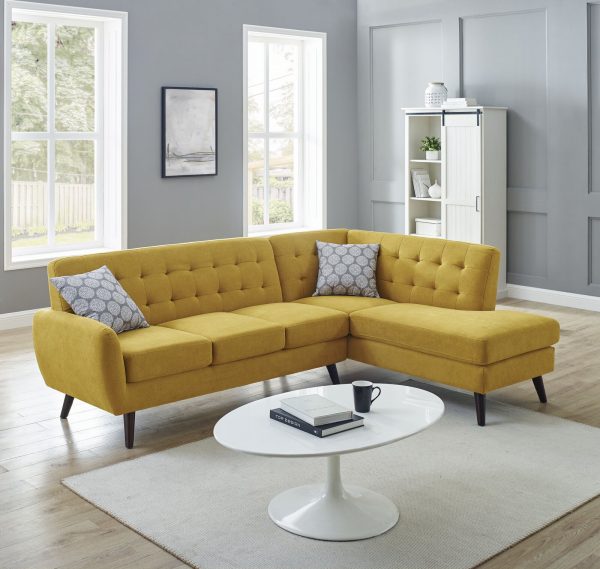 Sofa m&agrave;u v&agrave;ng nắng tinh tế cho ph&ograve;ng kh&aacute;ch Retro vui tươi hơn. Sự hiện diện của ghế sofa xua tan vẻ đơn điệu của ph&ograve;ng kh&aacute;ch m&agrave;u x&aacute;m trắng.