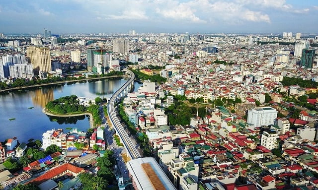 hình ảnh một góc thành phố nhìn từ trên cao với nhiều tòa nhà cao tầng xen kẽ khu dân cư thấp tầng, cây xanh
