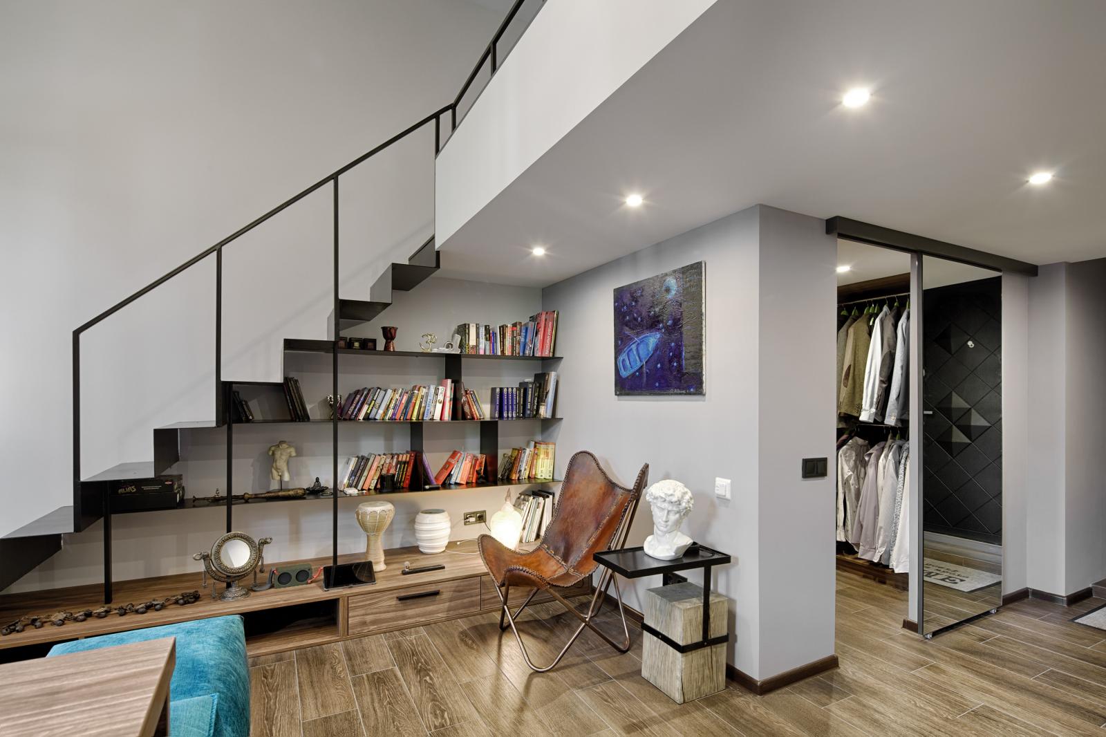 Gầm cầu thang gác lửng tận dụng làm giá sách hoặc tủ rượu tương tự như với các mẫu thang khác