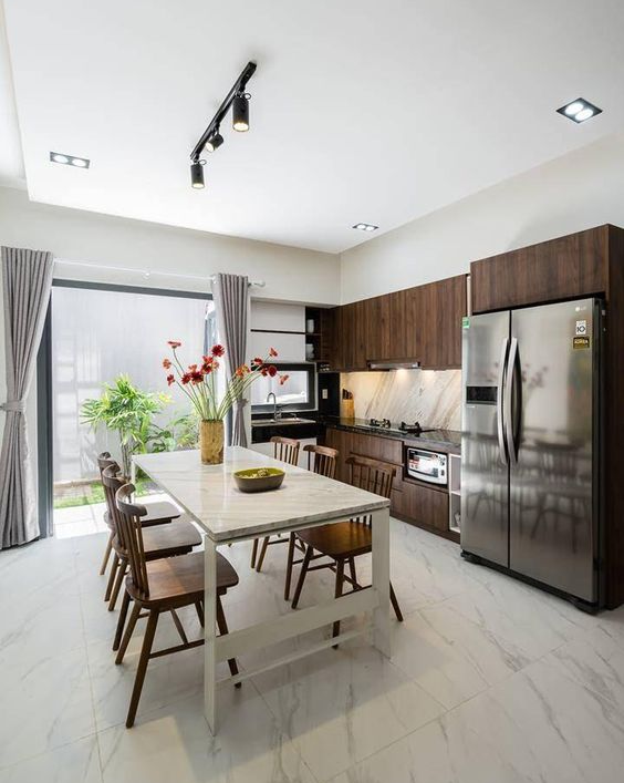 Phòng bếp kết hợp phòng ăn thoáng đãng Phòng bếp kết hợp phòng ăn luôn thoáng đãng và tận dụng được ánh sáng tự nhiên nhờ khung cửa cao rộng mở ra sân sau nhà.