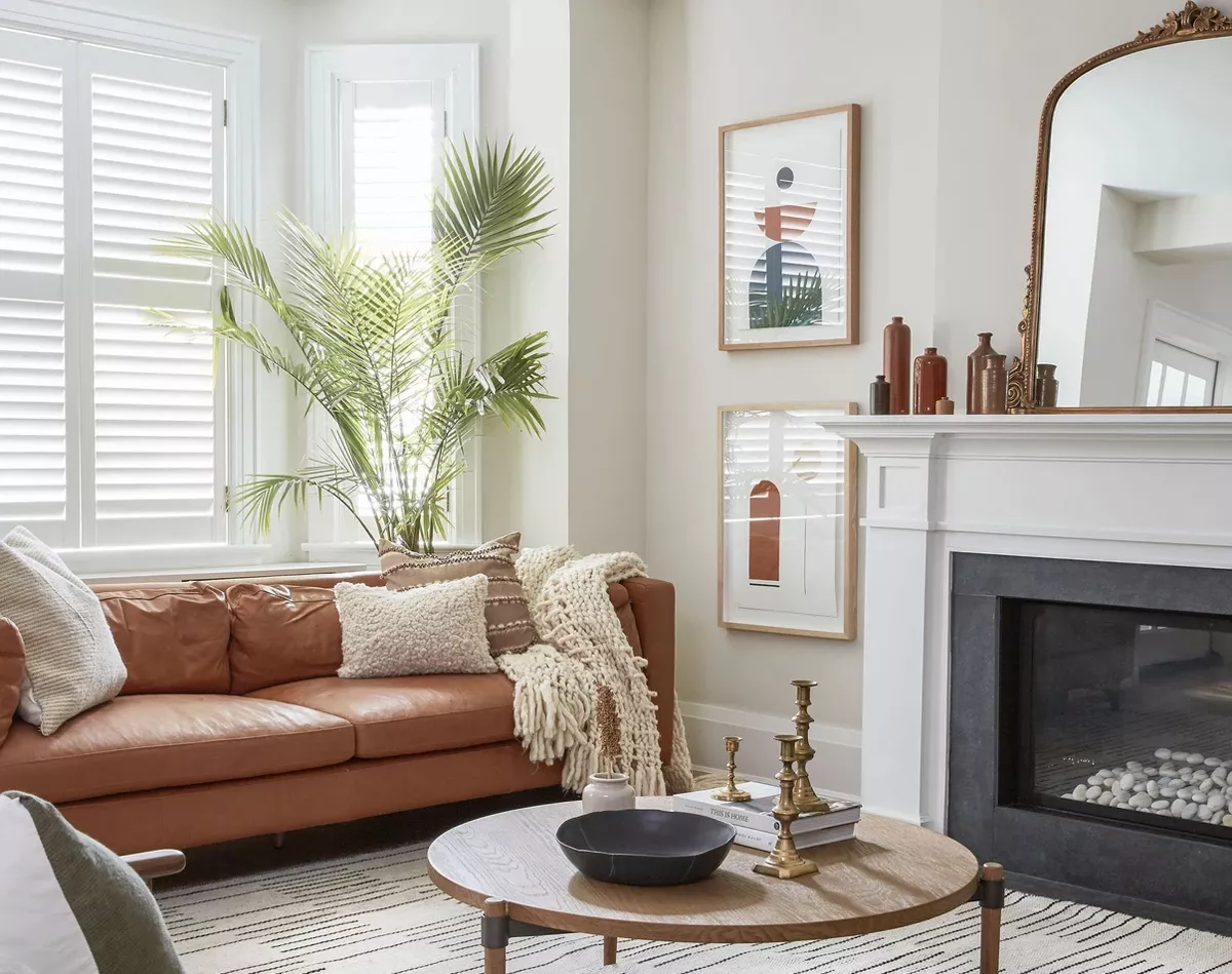 Ghế sofa màu nâu nổi bật trên phông nền màu trắng chủ đạo, tạo điểm nhấn ấm áp cho không gian tiếp khách của Xử Nữ.