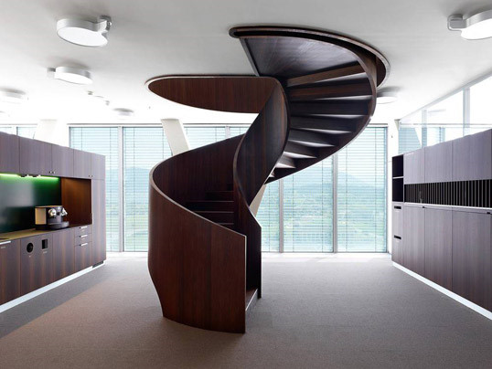 Cầu thang ở trung tâm ngôi nhà. Cầu thang xoắn bằng gỗ màu nâu giữa nhà