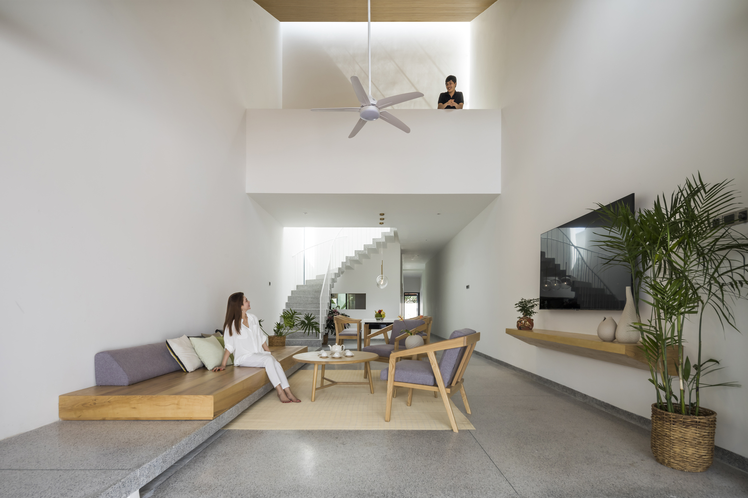 ph&ograve;ng kh&aacute;ch nh&agrave; đẹp với h&igrave;nh ảnh c&ocirc; g&aacute;i ngồi tr&ecirc;n sofa gỗ