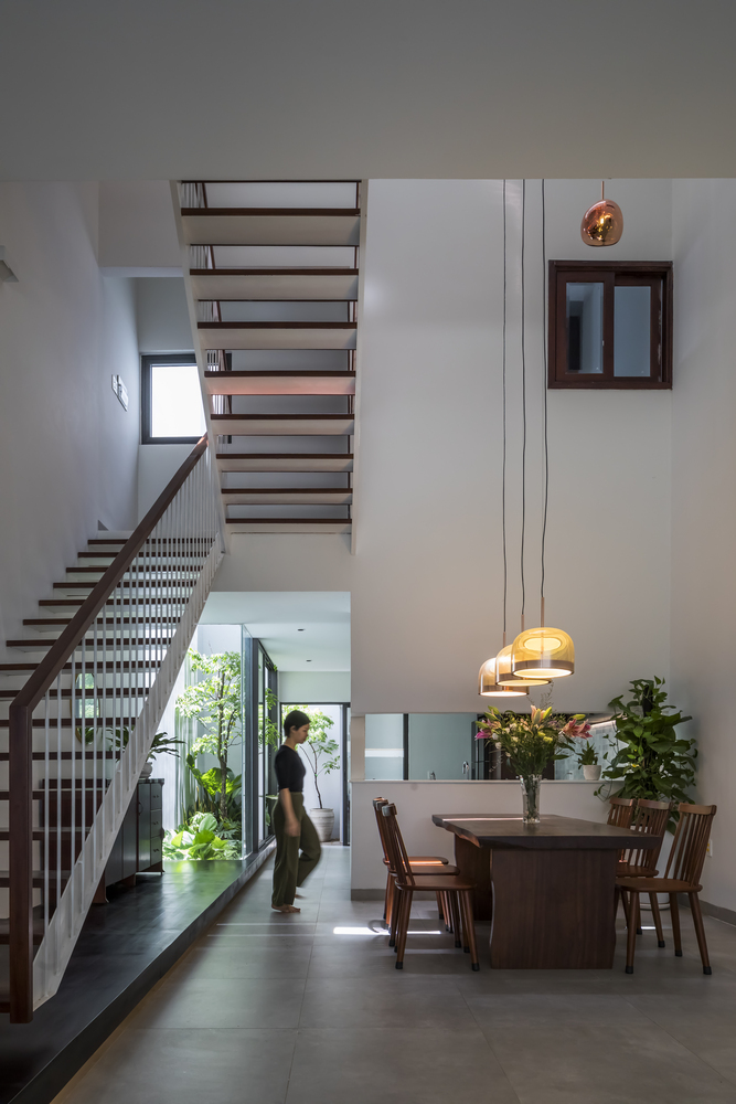 Ánh sáng tự nhiên vào nhà thông qua khe lấy sáng trên mái, tán xạ xuống các mảng tường lớn ở khoảng thông tầng, soi sáng khu vực bàn ăn ở tầng trệt.