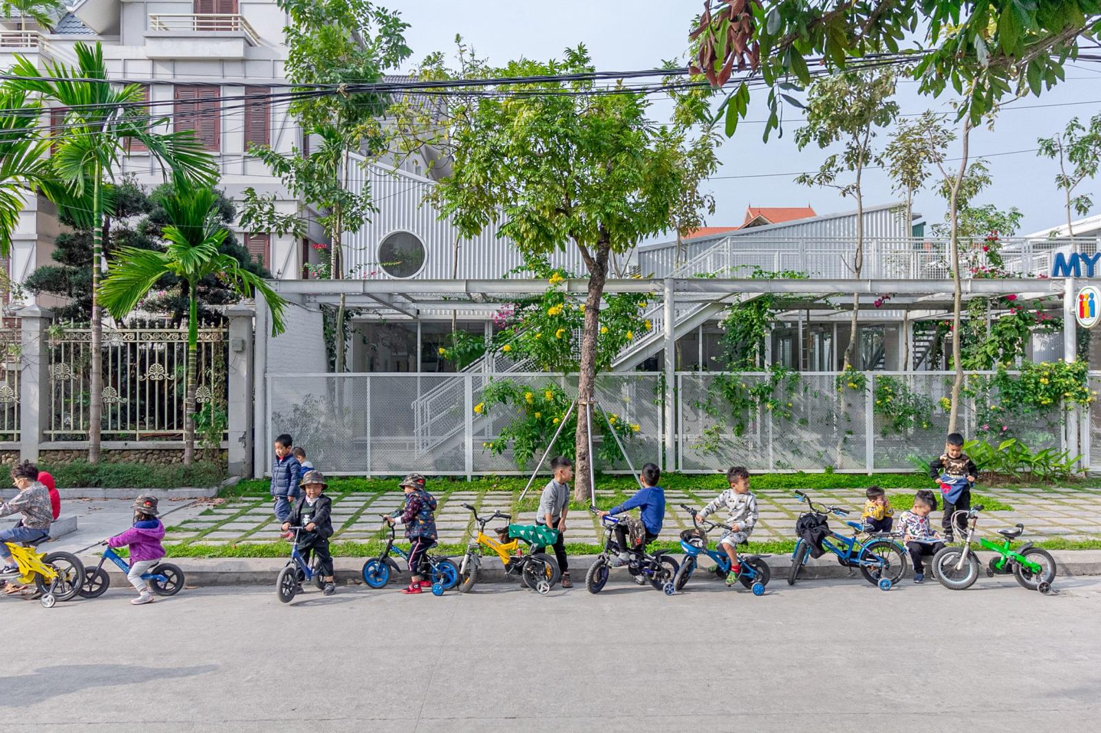 C&aacute;c loại c&acirc;y, hoa th&acirc;n leo đang ph&aacute;t triển tr&ecirc;n h&agrave;ng r&agrave;o lưới trắng của ng&ocirc;i trường.