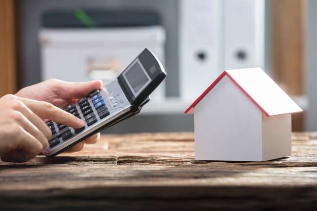 hình ảnh cận cảnh máy tính cầm ty, mô hình ngôi nhà minh họa cho thuế cho thuê nhà