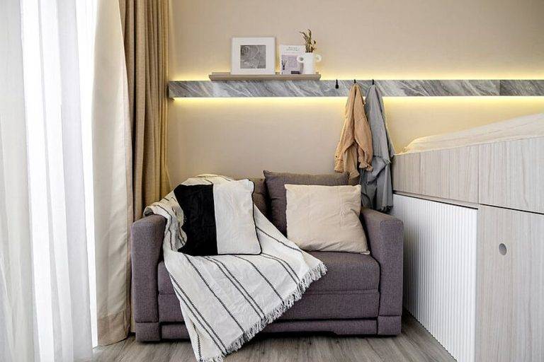 Gờ tường được chiếu s&aacute;ng tạo hiệu ứng thị gi&aacute;c th&uacute; vị. Ghế sofa c&oacute; thể biến th&agrave;nh giường phụ cho kh&aacute;ch khi cần thiết.
