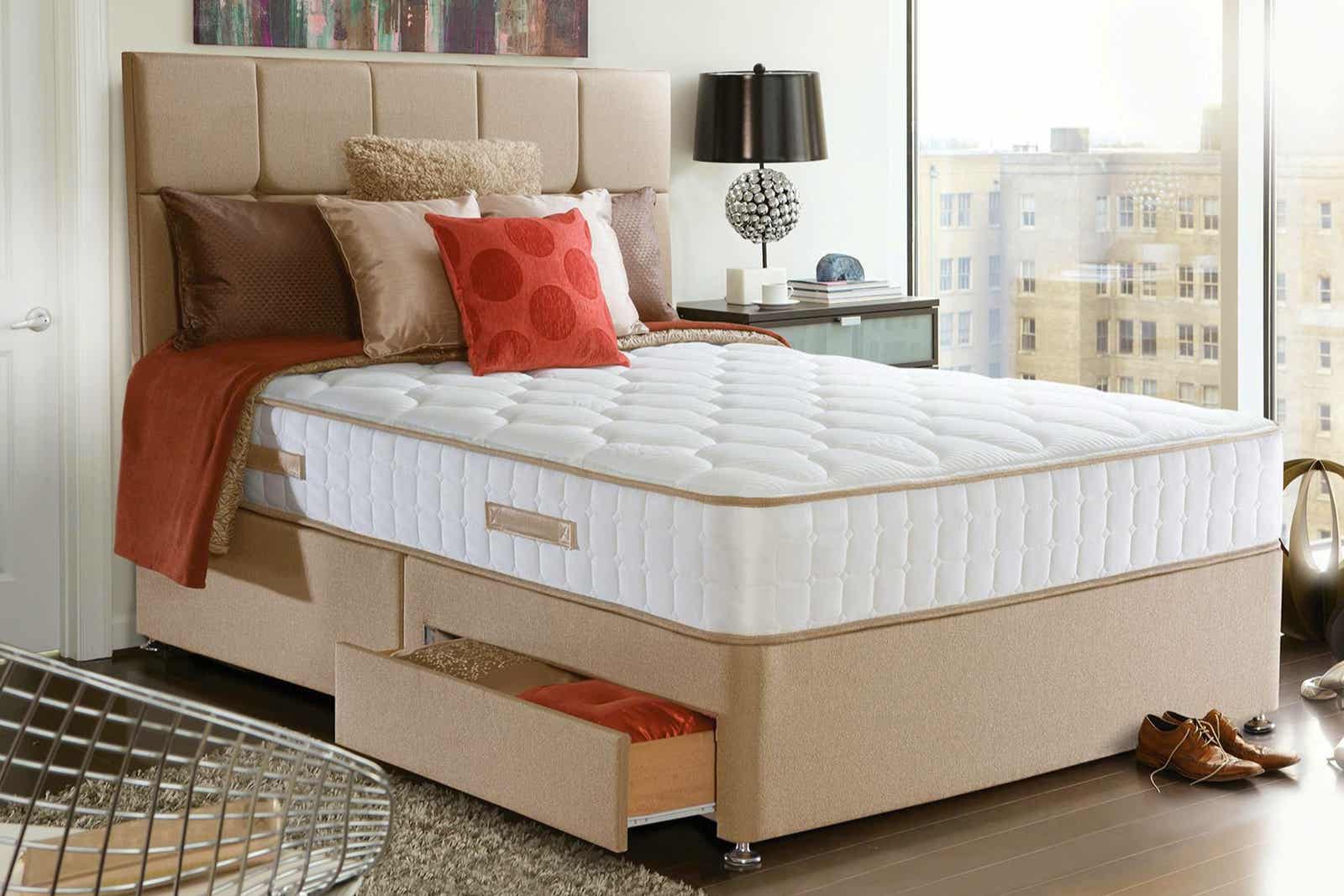 giường ngủ với nệm màu trắng cao, gối màu đỏ cam, nâu, be đậm