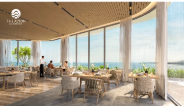 A room with tables and chairs and a view of the oceanDescription automatically generated with low confidence